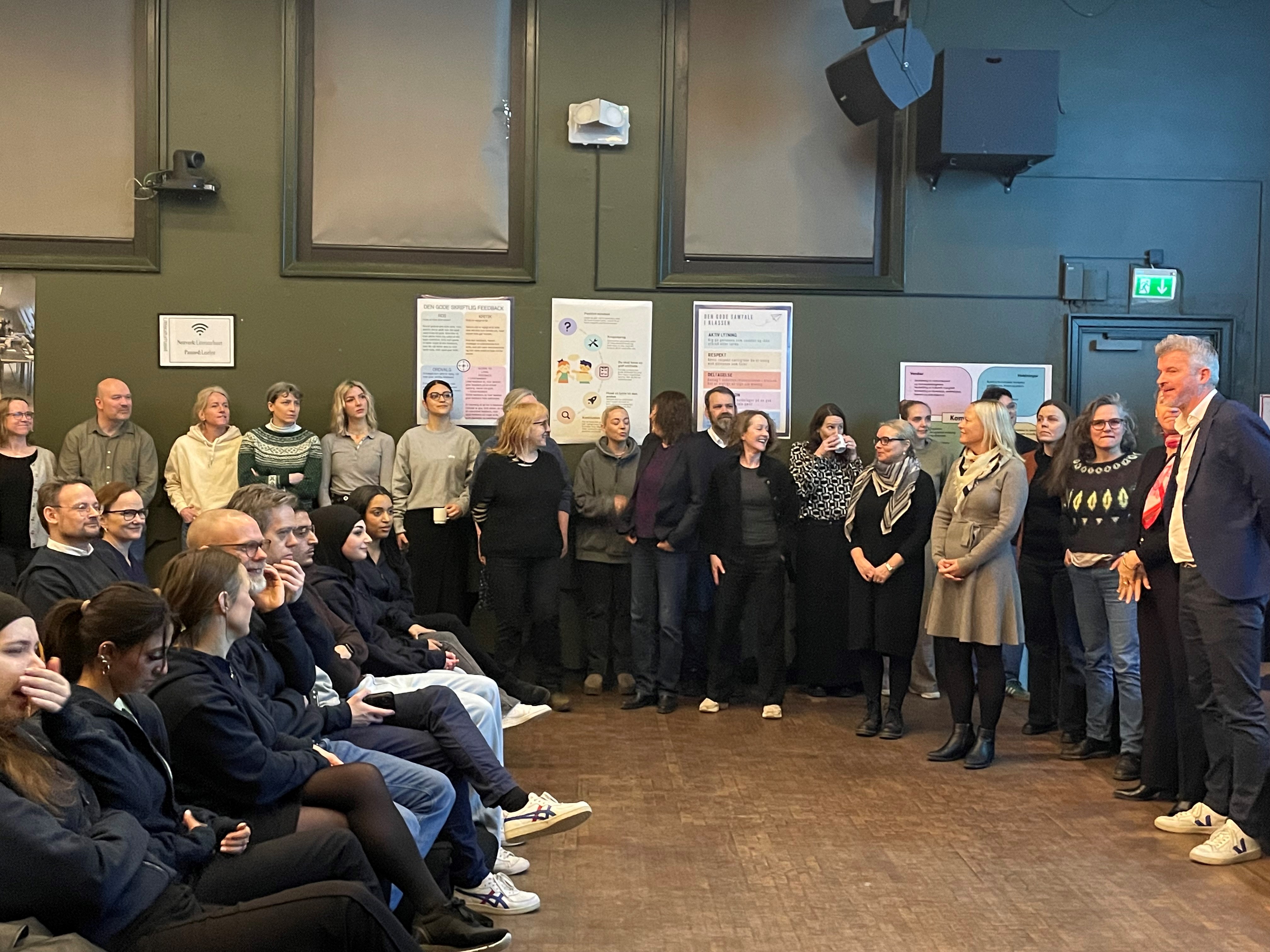 en gruppe mennesker som står i et rom