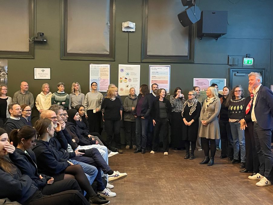 en gruppe mennesker som står i et rom