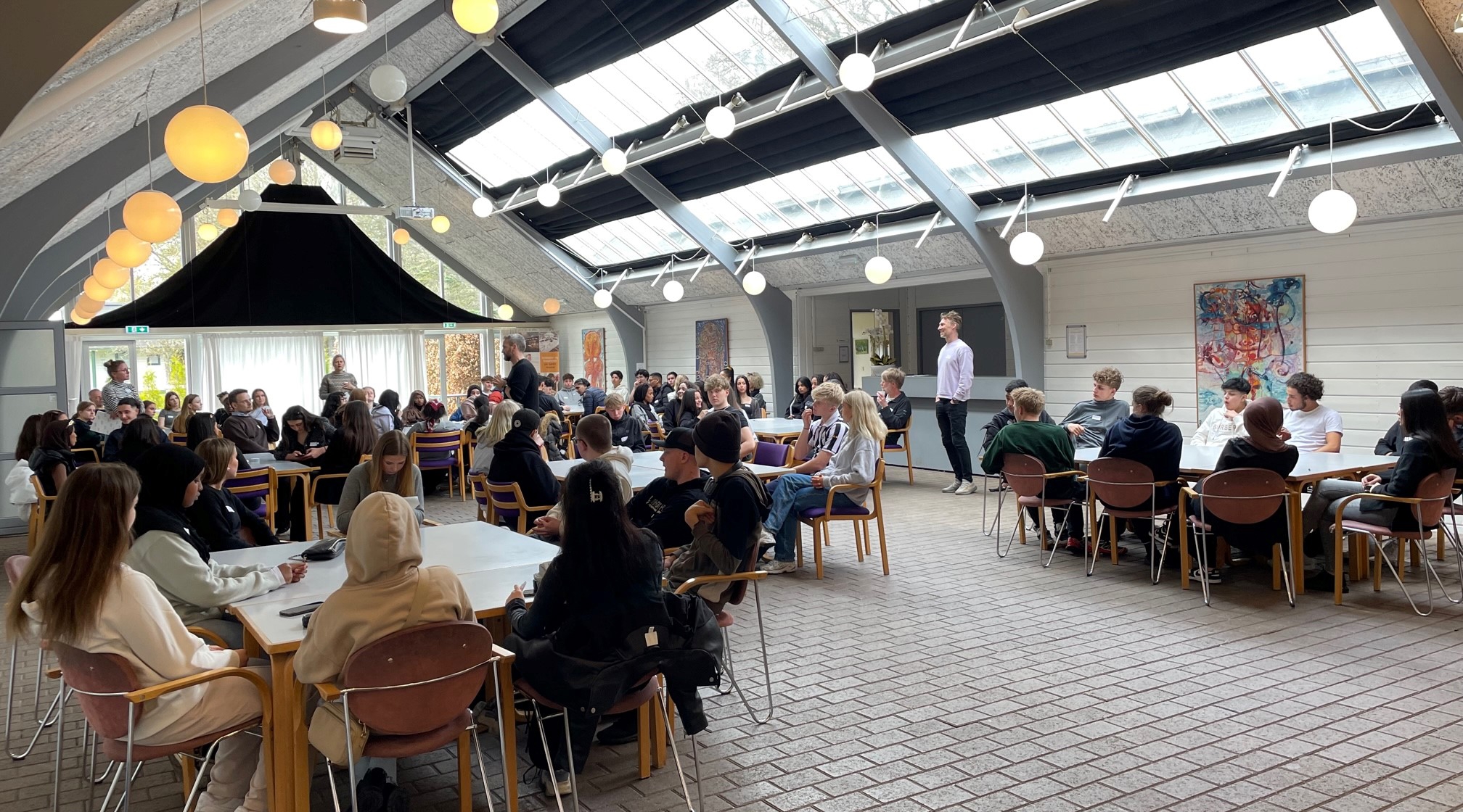 en gruppe mennesker som sitter ved bord