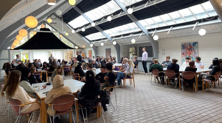 en gruppe mennesker som sitter ved bord