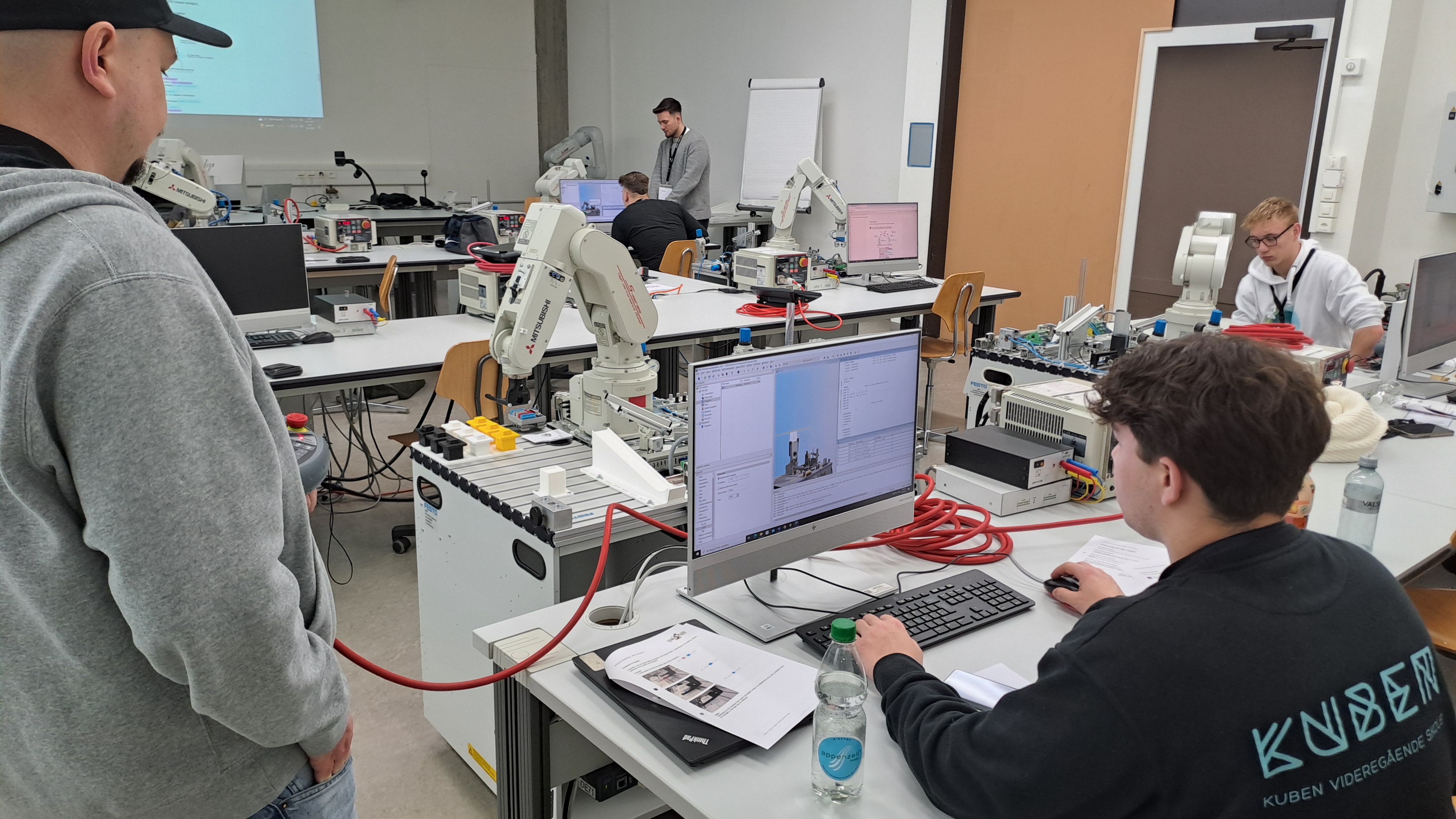 GBS St Gallen 2025-02 - Karl i arbeid en gruppe mennesker i et rom programmerer roboter