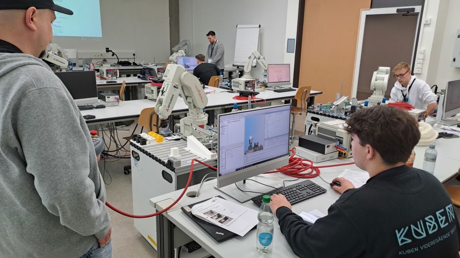 Foto: GBS St Gallen 2025-02 - Karl i arbeid en gruppe mennesker i et rom programmerer roboter