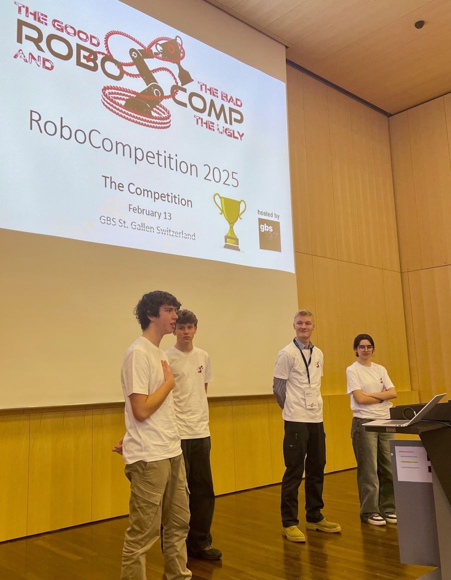 Foto: GBS St Gallen 2025-02 - Sara med team presenterer en gruppe elever som står foran en storskjerm