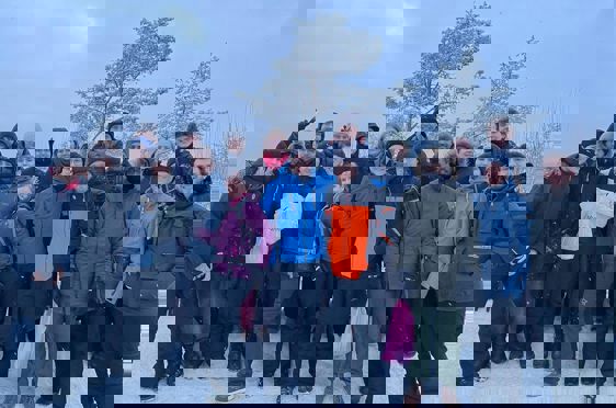 en gruppe mennesker som poserer for et bilde i snøen