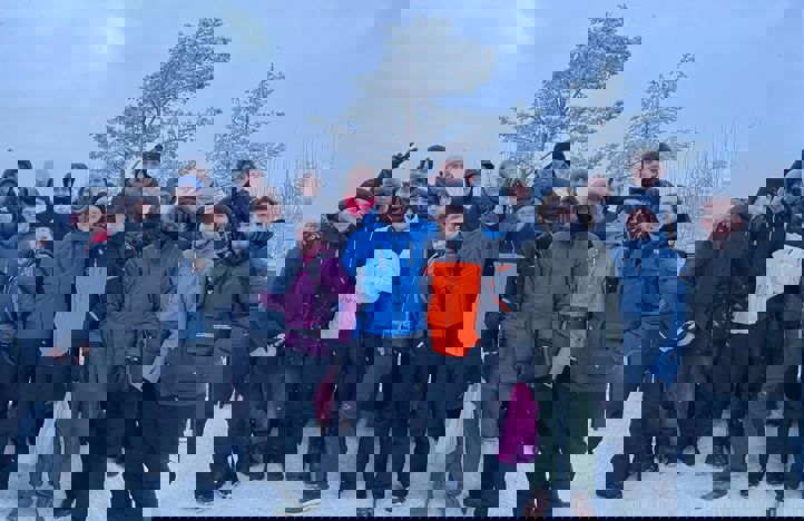 en gruppe mennesker som poserer for et bilde i snøen