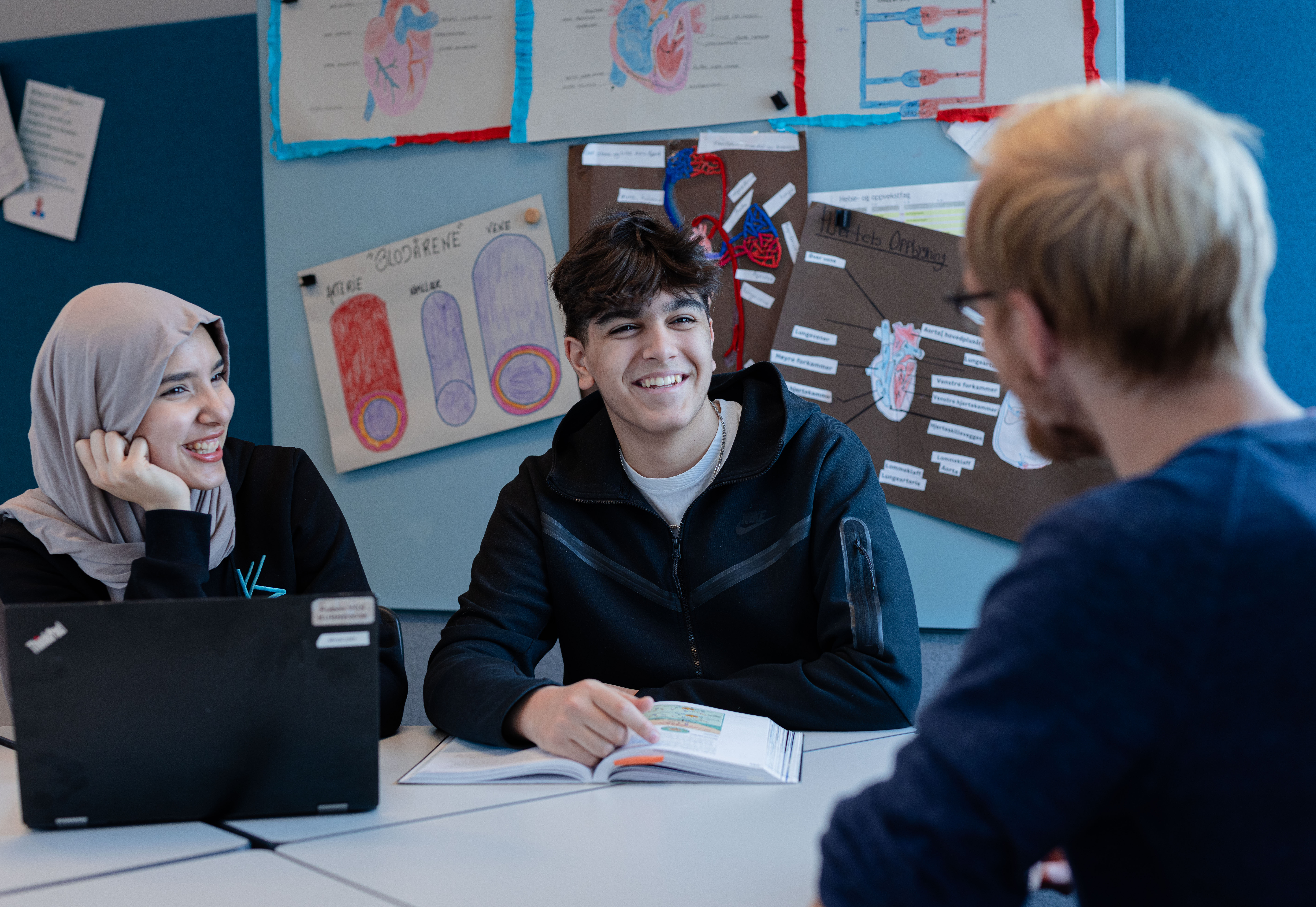 en gruppe mennesker som sitter ved et bord