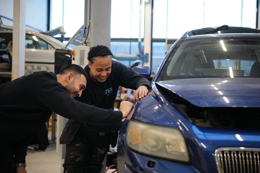 Foto: UDE v Matias Fosso et par elever som jobber med en bil