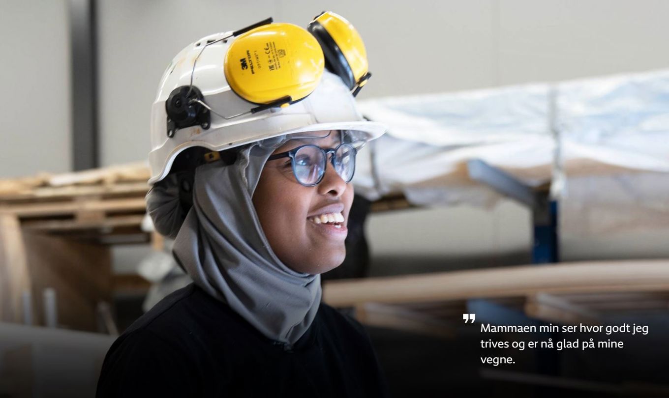 Bilde av Aisha som smiler med hjelm og hørselsvern på