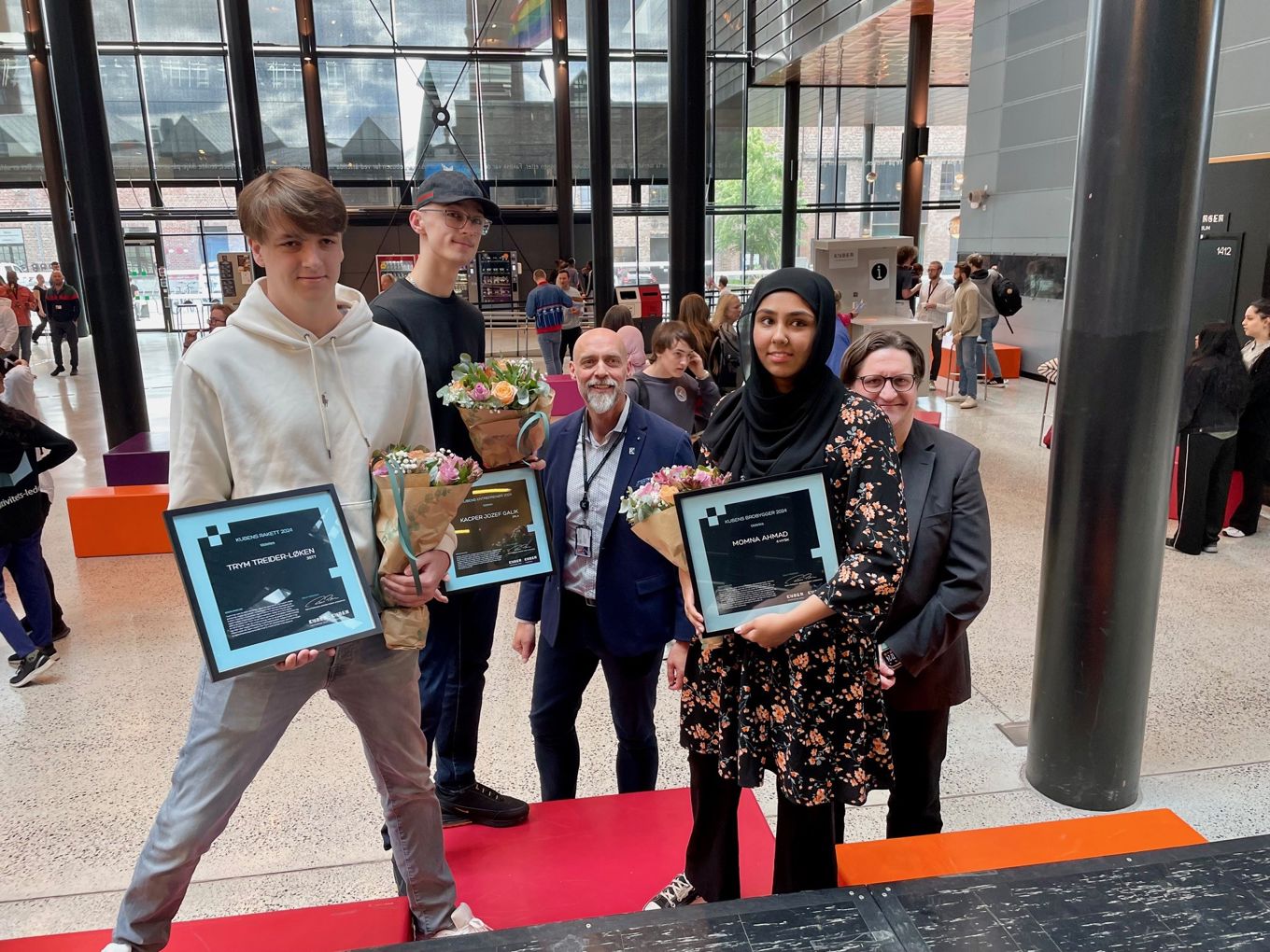 Kubenprisvinnerne Trym, Kacper og Momna, med rektor og direktør i bakgrunnen
