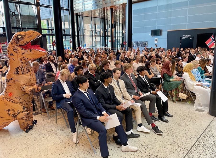 Foto: Publikum, elever og dinosaur Publikum og dinosaur