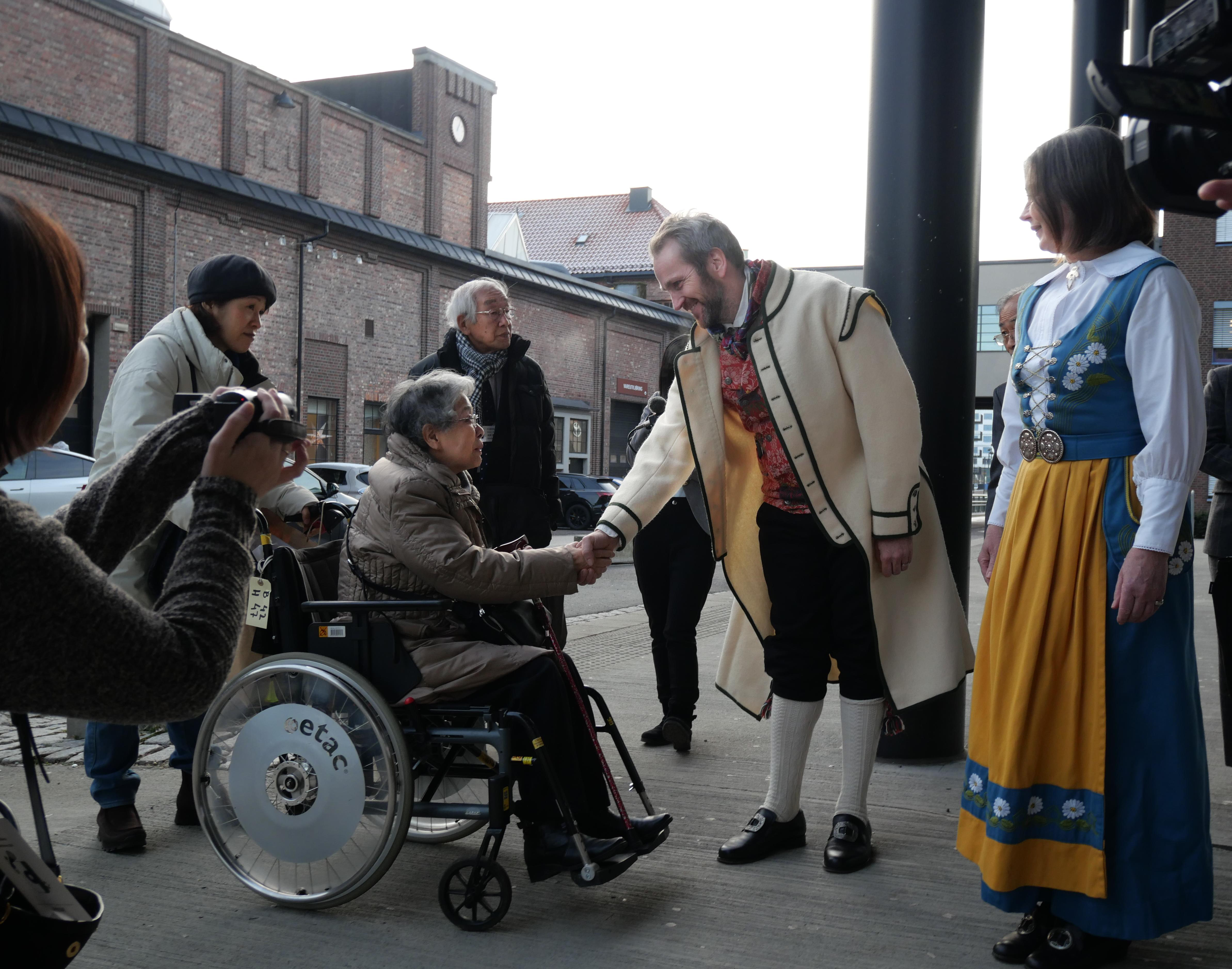 en person i et plagg som dytter en person i rullestol