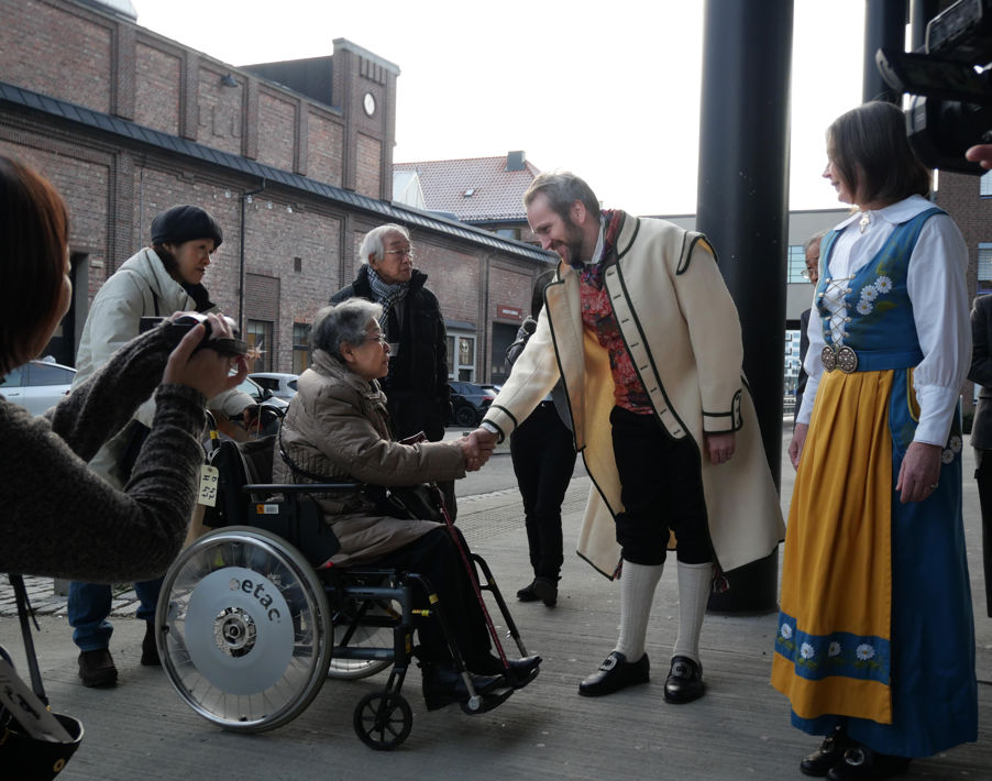 en person i et plagg som dytter en person i rullestol