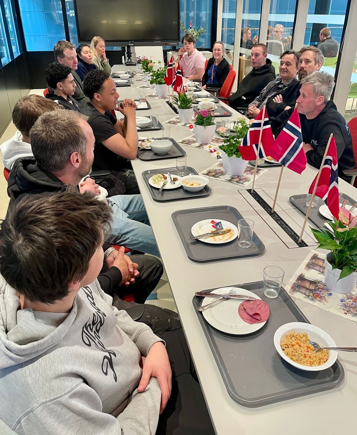 en gruppe mennesker som sitter ved et bord og spiser mat