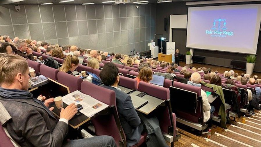 en gruppe mennesker som sitter i et forelesningssal