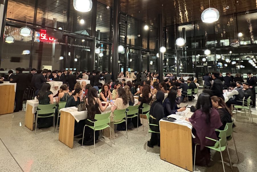 Foto: Middag i kantina en stor gruppe mennesker som satt ved bord i et stort rom